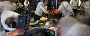 McLaren mechanics appear blurred with activity in this shot of the team's garage