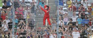 Helio Castroneves climbs the fence to celebrate his Texas victory