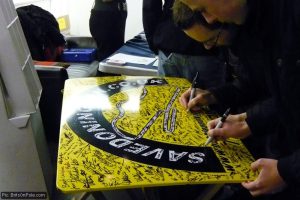 Supporters sign a 'Bubble and Kick' racing Porsche roof panel