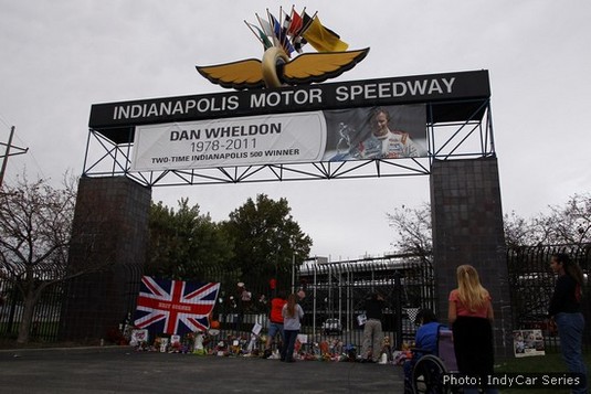 Fans gather to lay tributes beneath the memorial banner at the Indianapolis Motor Speedway